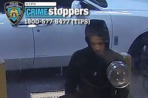 Surveillance footage of a man in a black hoodie next to a white car, with a "Crime Stoppers" banner overlaid.