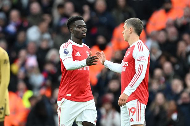 Bukayo Saka shakes hands with Leandro Trossard of Arsenal as he is substituted off