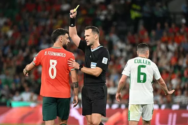 Portugal's Bruno Fernandes (left) is shown a yellow card