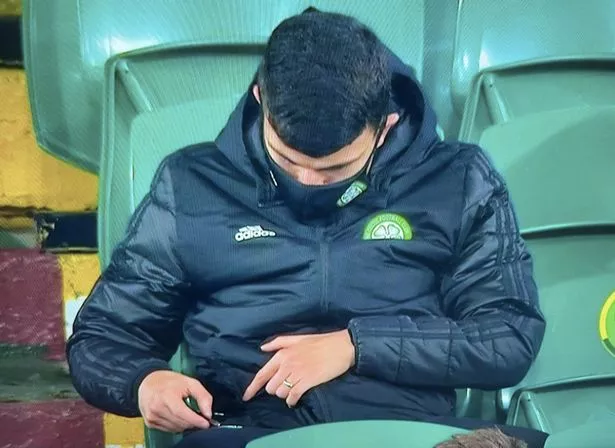Mo Elyounoussi has a quick check of his phone in the stand