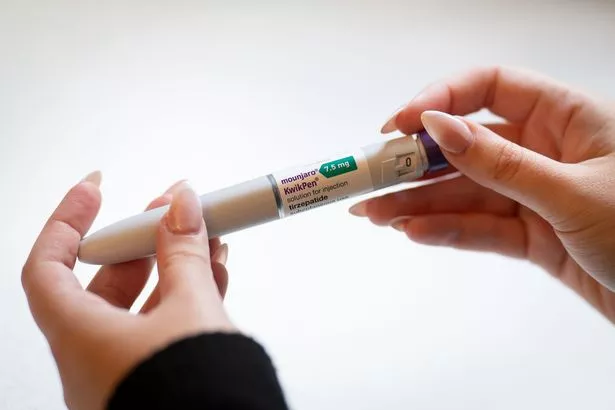 A woman holds a Mounjaro injection pen