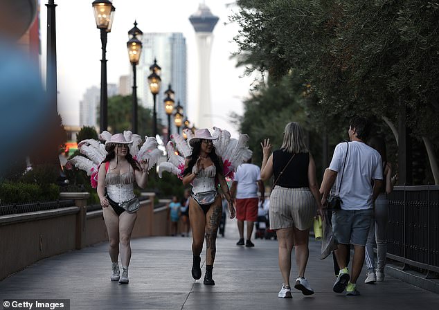 Las Vegas saw 4.56 million passengers visit in August which was a drop of 6 percent compared to the same time last year. Women dressed as showgirls wave to visitors walking along the Las Vegas Strip