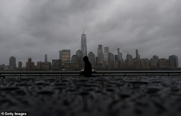 Newark Liberty International Airport, LaGuardia Airport and Kennedy Airport saw 18 cancelled flights and more than 200 delays by late Sunday evening Pictured: skyline of lower Manhattan