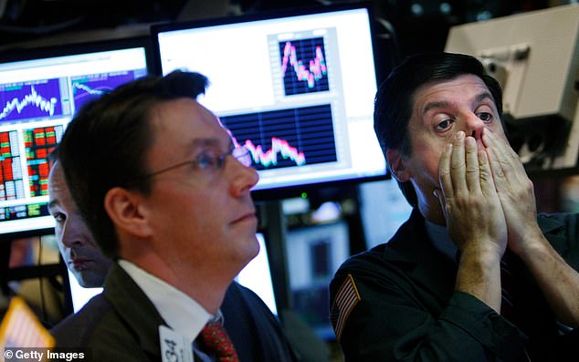 Dalio famously predicted the 2008 financial crash. Pictured, a trader rubs his face while working on the floor of the New York Stock Exchange in October 2008