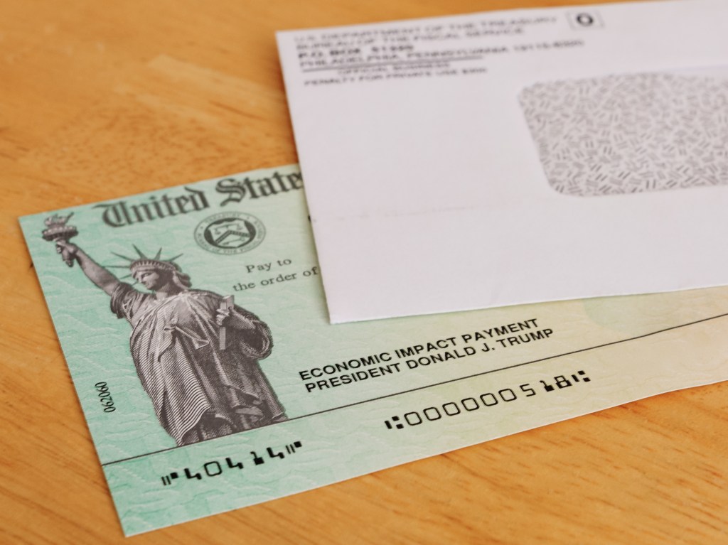 United States Treasury economic impact check with President Donald J. Trump's name printed on it and a white envelope.