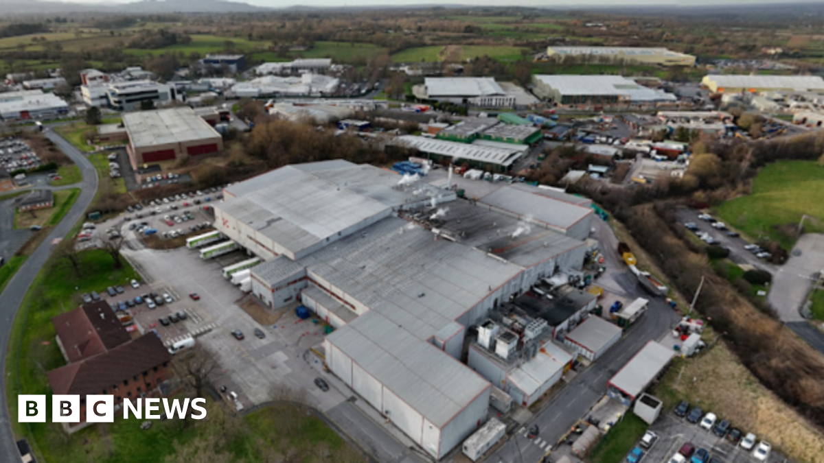 Sana el-Azab is sitting on a wall circling Durham Cathedral. She is smiling and is doing a peace sign with her hands.