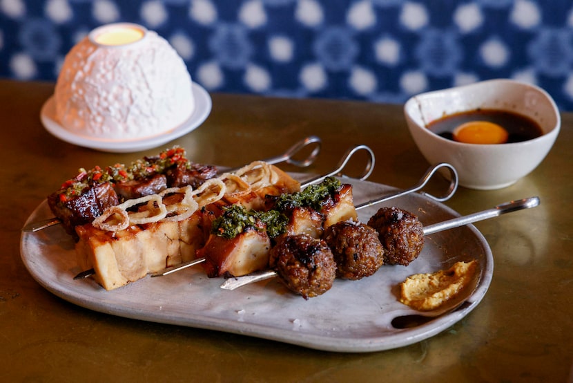 Skewers of rosewood NY strip (from left), jidori chicken, charred octopus and duck and...