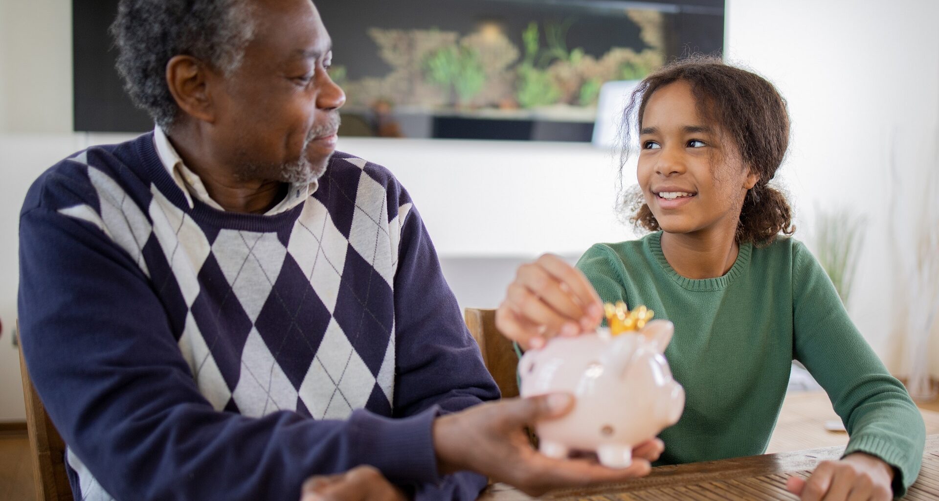 Grandfather teaches his granddaughter healthy saving habits stock photo