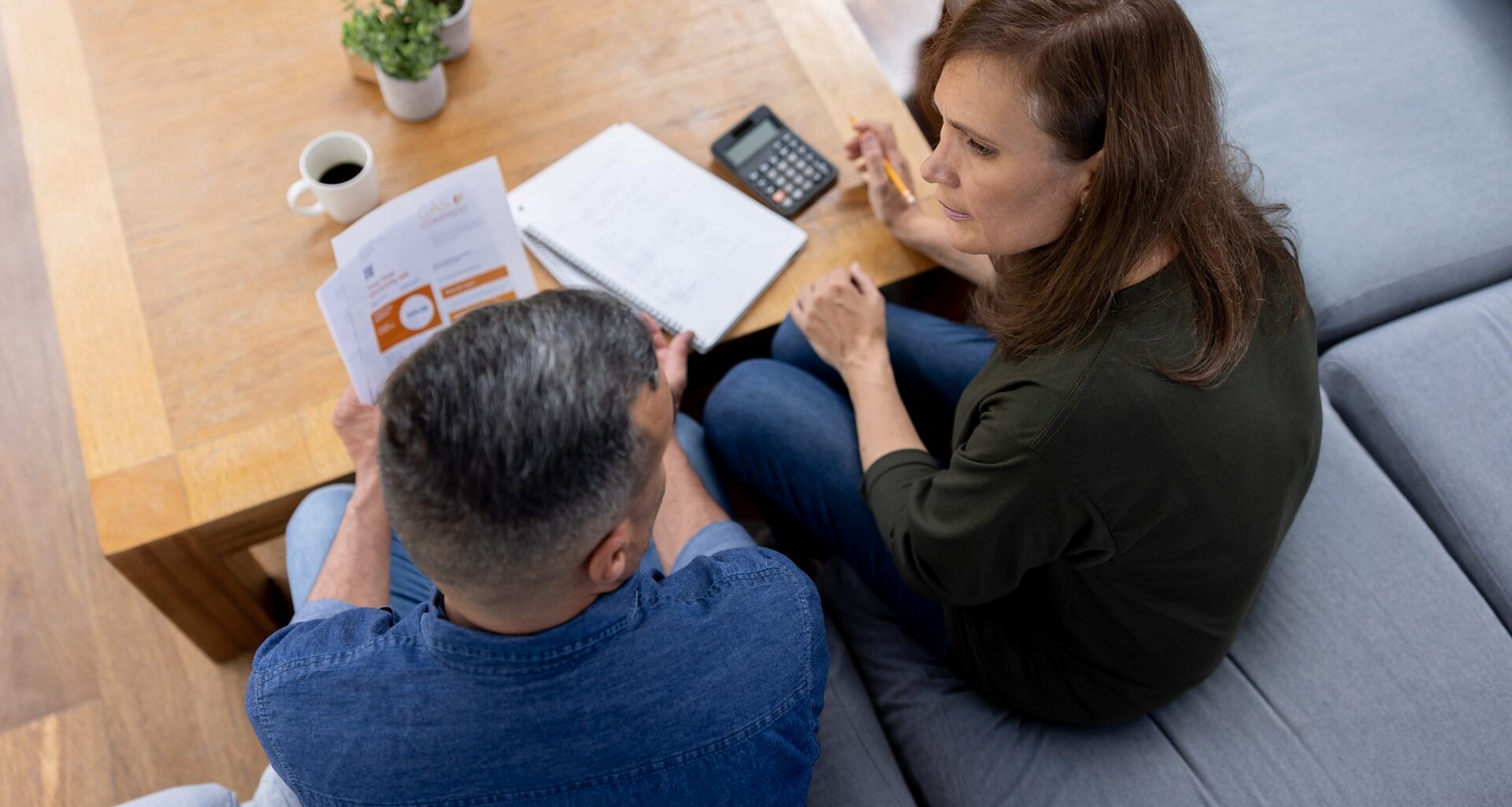 A couple sitting at home having a serious discussion about their household budget and personal finances.