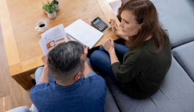 A couple sitting at home having a serious discussion about their household budget and personal finances.