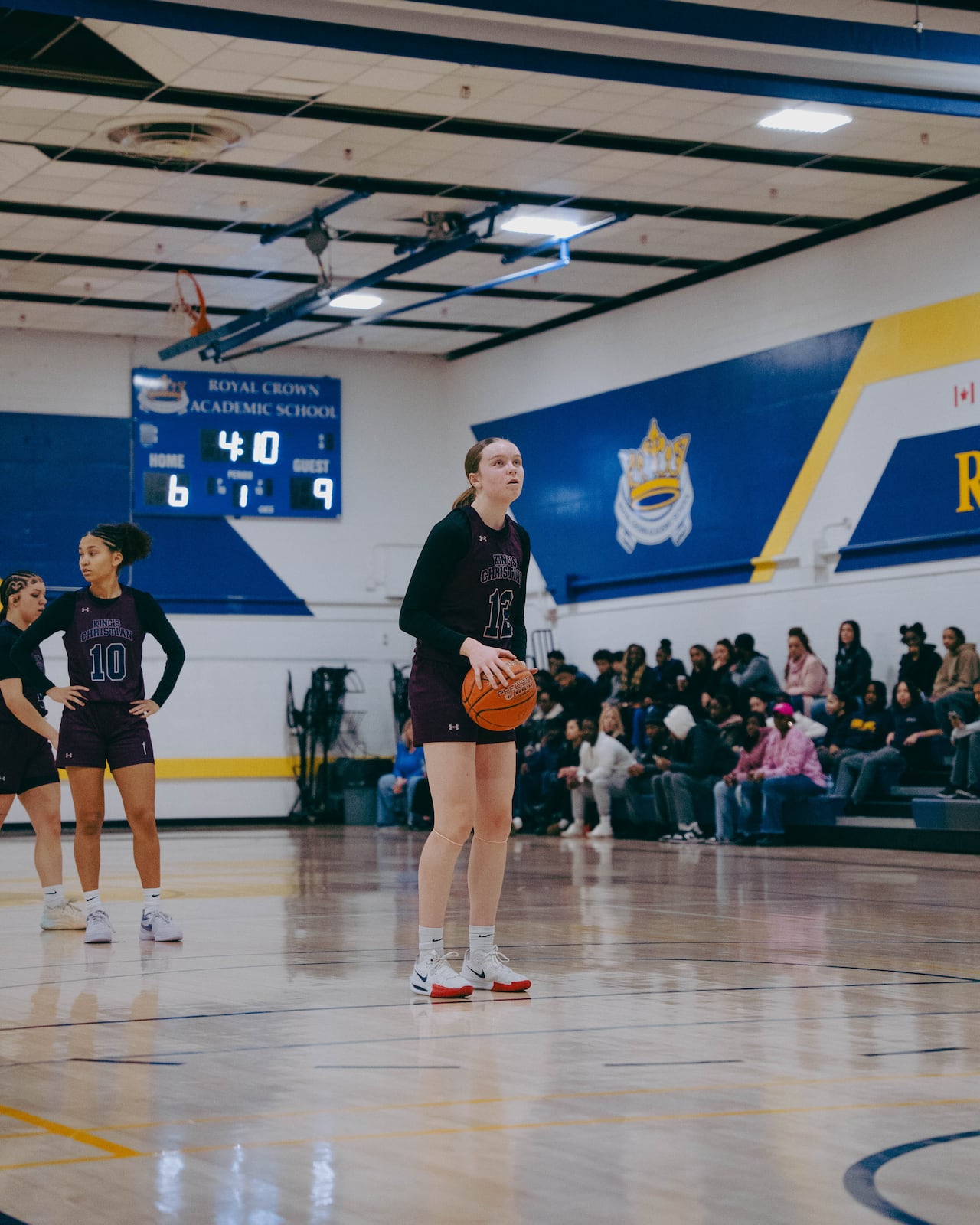 A basketball player stands on the court waiting to take a shot.