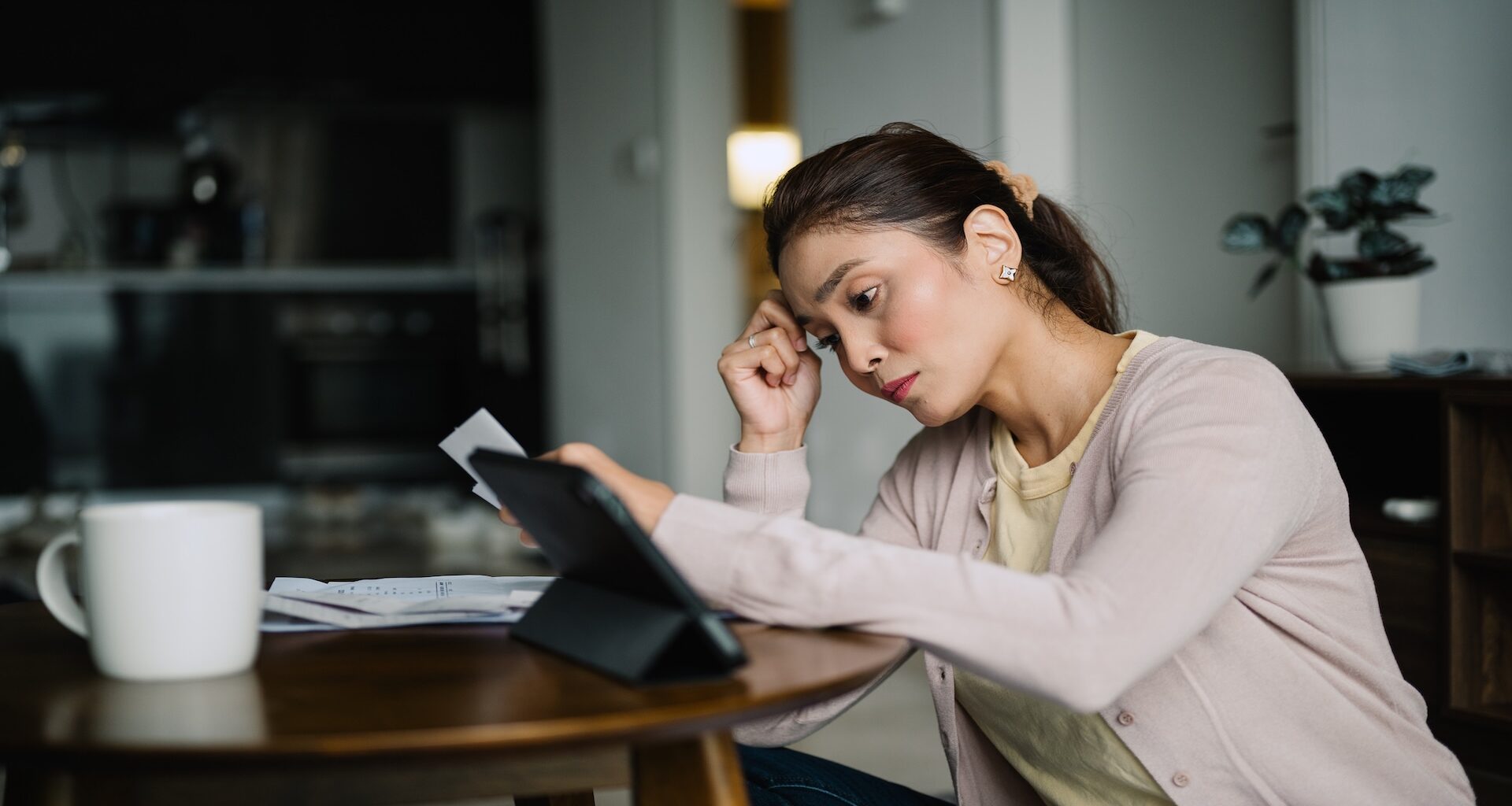 Asian Malay female planning family finances at home.