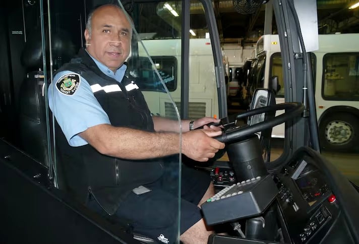 A bus driver sits behind the wheel