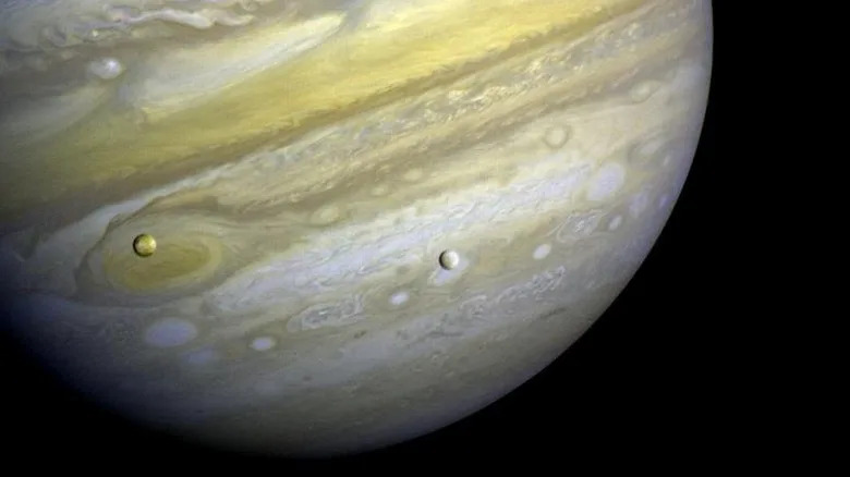 An image taken by Voyager 1 of Jupiter and its two satellites, Io and Europa.