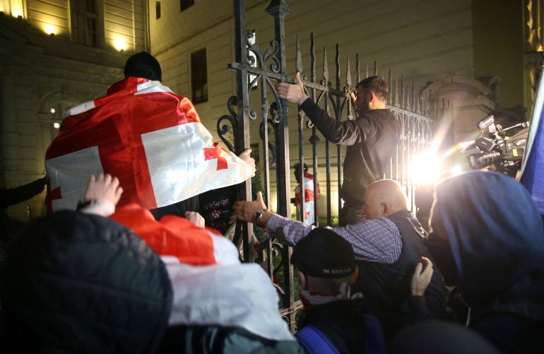 Protesters attempt to break into the presidential palace grounds during an opposition rally