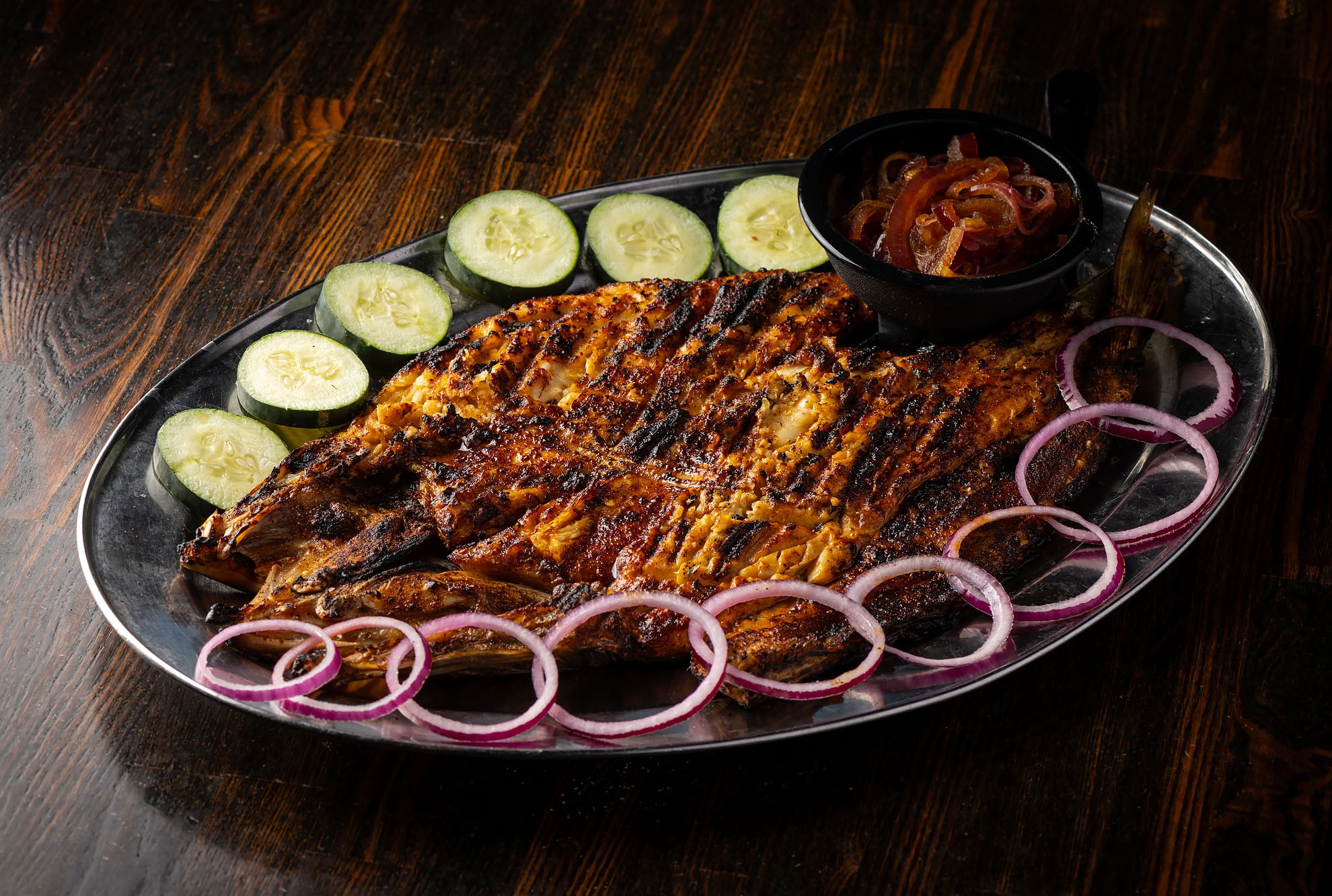 A whole grilled snook served Nayarit-style at Coni’Seafood on a silver plate.