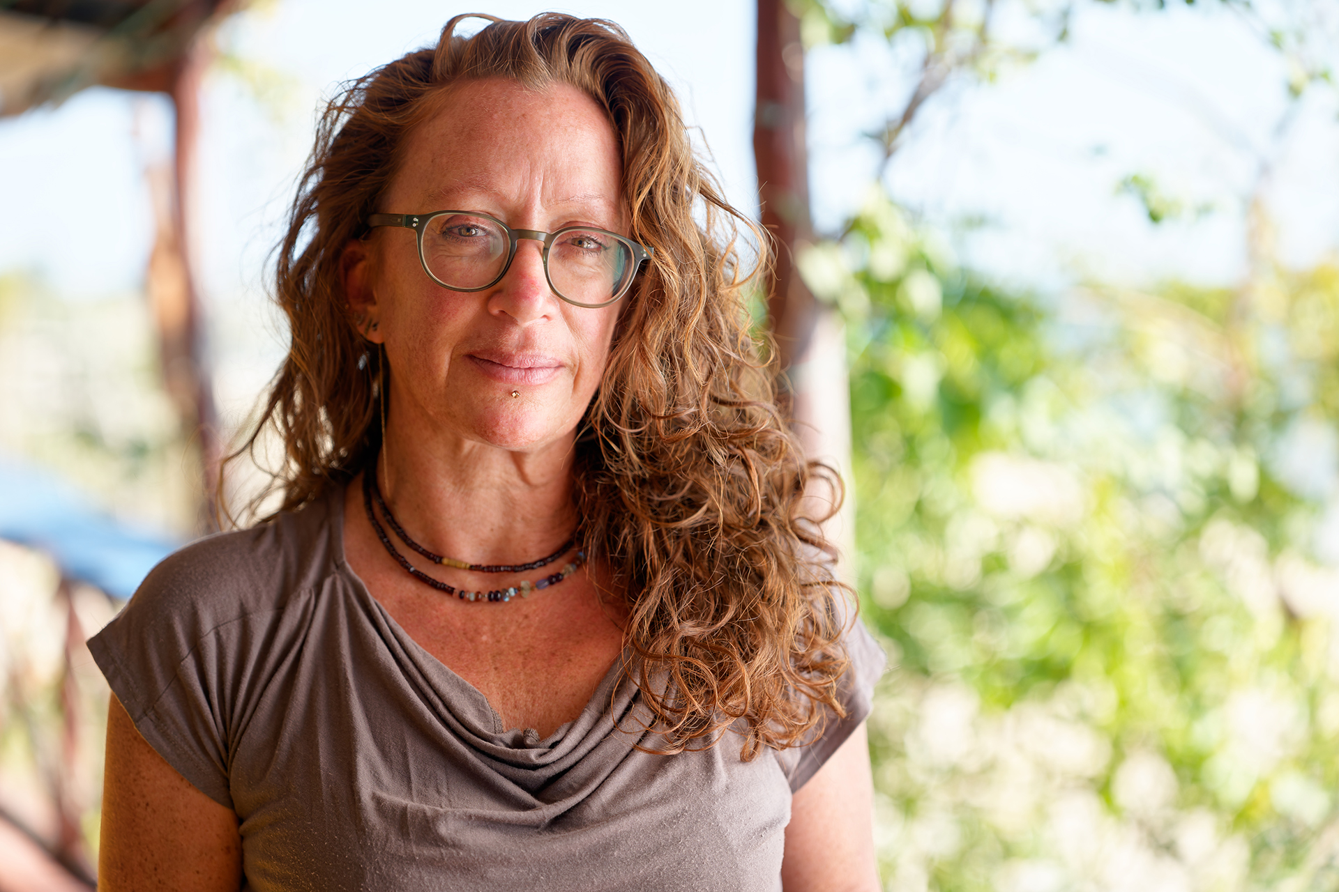 Emma Gibbons wears glasses and has long curly reddish hair.