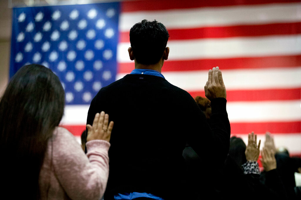 FILE - In this Feb. 15, 2017 file photo, people take the oath of citizenship during a naturalization ceremony at the Los Angeles Convention Center. A new citizenship test is rolling out this year, and Valley groups are helping applicants prepare.