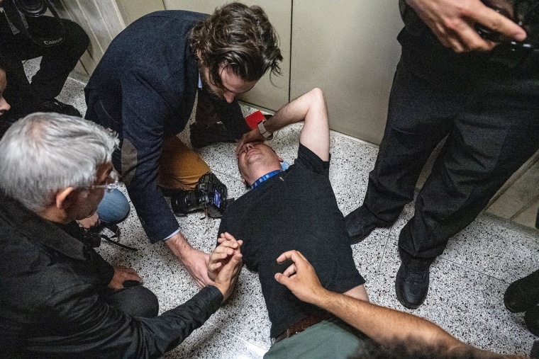 L. Vural Elibol, a visual journalist for the Andalou Agency, is tended to after being thrown to the ground and injured by federal agents at the Jacob K. Javits federal courthouse on September 30, 2025 in New York City.