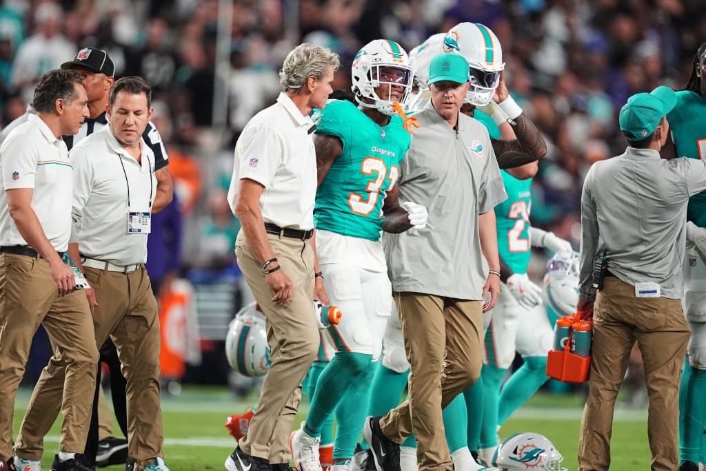 Miami Dolphins running back Ollie Gordon II (31) being helped off the field after an apparent injury.