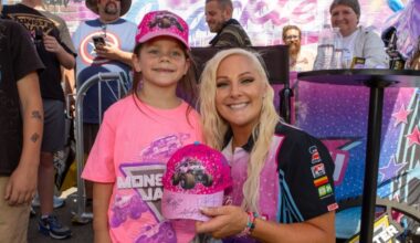 a woman and a girl pose with a Monster Jam hat