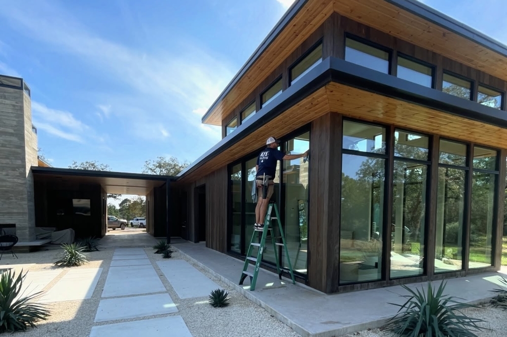 a person cleans windows of a house