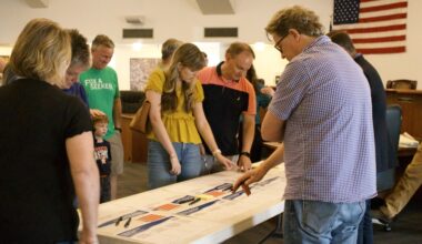 people point at papers on a table