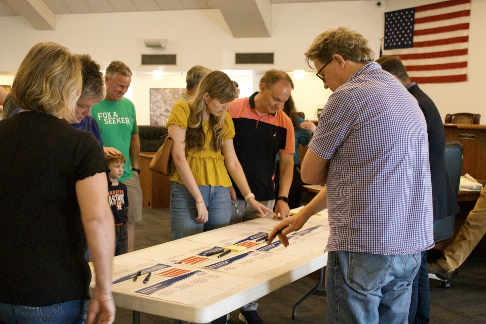 people point at papers on a table