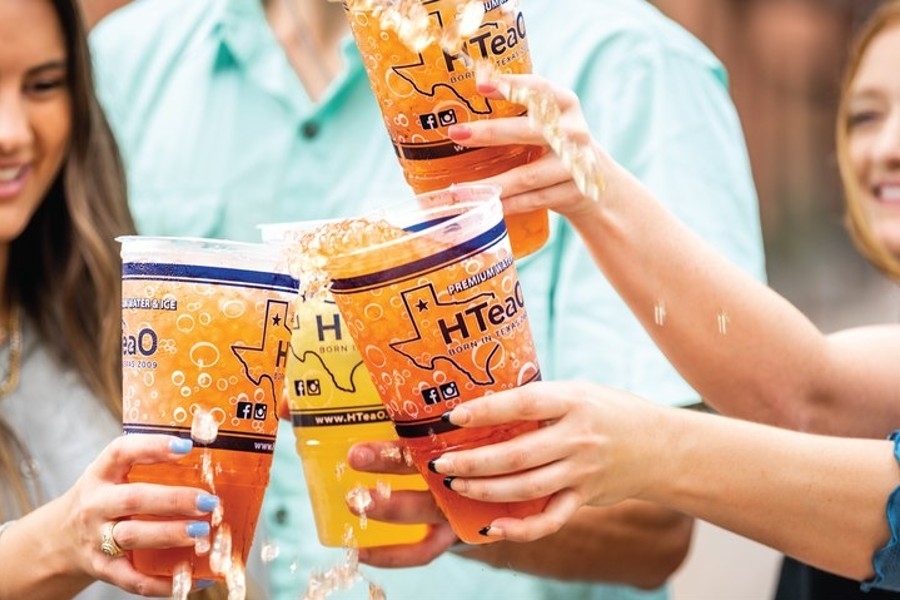 A promotional photo of people clinking their teas.
