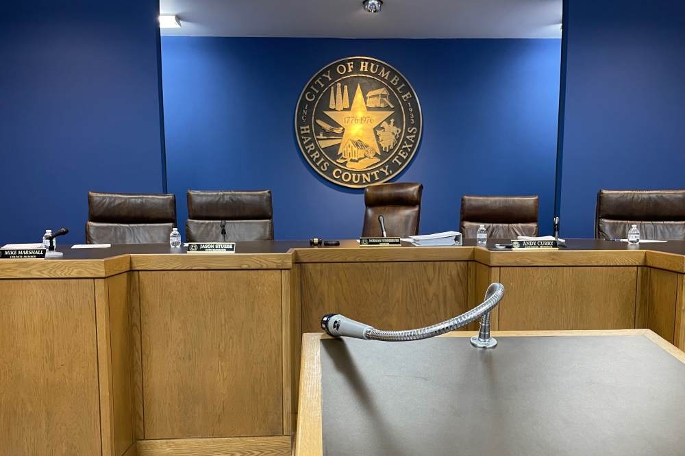 a city council meeting room with black chairs and blue walls