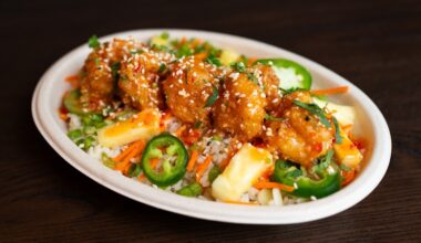 Overview of a bowl filled with meat, jalapeno slices, rice, seasonings and more.