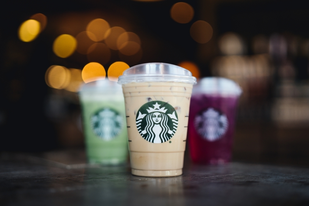 Three drinks from Starbucks are seen on a wooden table as a promotional photo from the company.