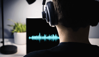 Producer at a computer with a sound wave on a screen.