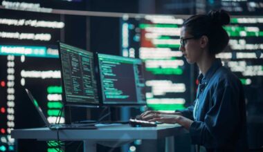 Female Developer Thinking and Typing on Computer, Surrounded by Big Screens Showing Coding Language. Professional Programmer Working in an Office, Running Coding Tests. Futuristic Programming