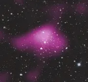 A gif of a deep space image with a purple blob of light appearing on top of the image and then disappearing showing a dark matter heat map of sorts.