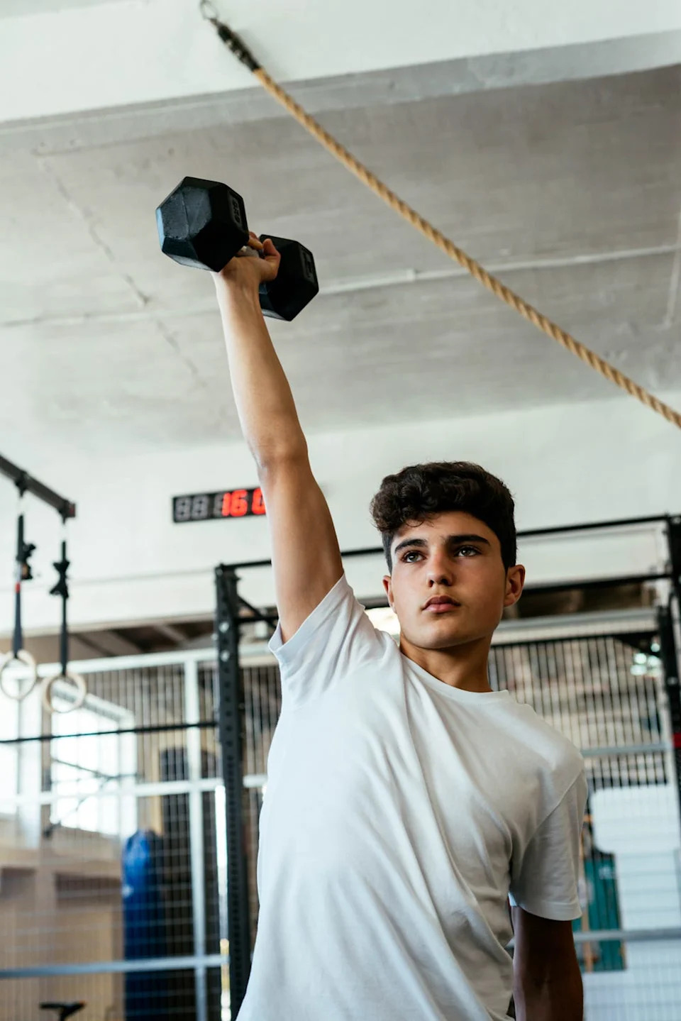 person lifting a dumbbell in a gym setting