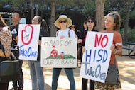 People hold up signs at a news conference, Friday, March 3, 2023, in Houston while...