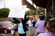 Jessica Cruz holds up a poster that says “Stand against domestic violence” as family and...