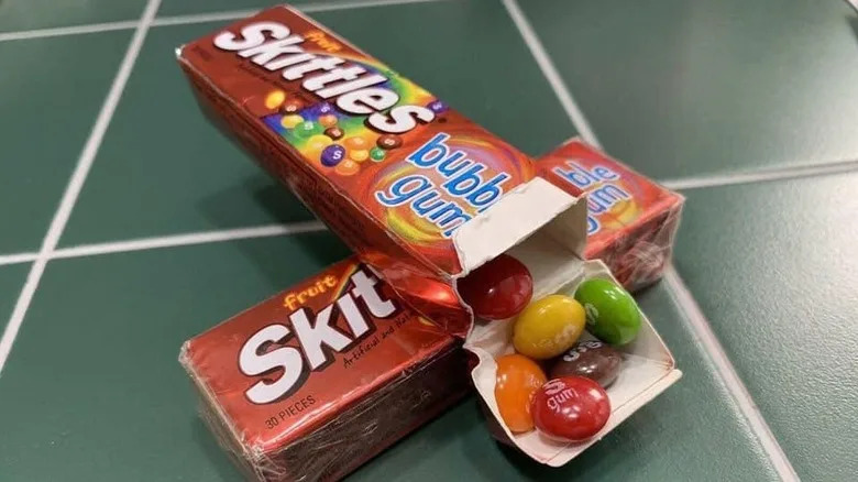 two boxes of Skittles gum stack on top of eachother with one box open showcasing the gum