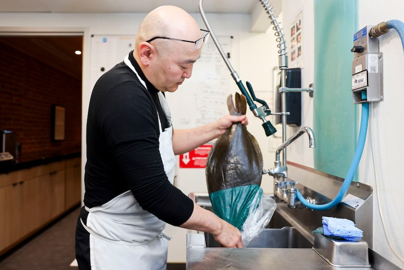 Chef Tatsu cleans a whole flounder after picking up cases of fresh fish flown in from Japan.