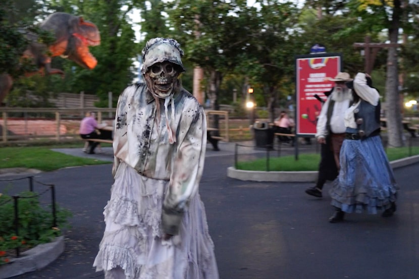 A video screenshot shows actors walking around Six Flags over Texas during a Fright Fest...