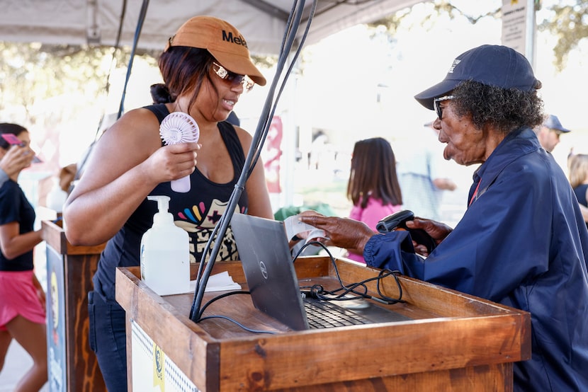 State Fair of Texas employee Faye Thomas, 87, scans tickets for fairgoers at an entrance to...