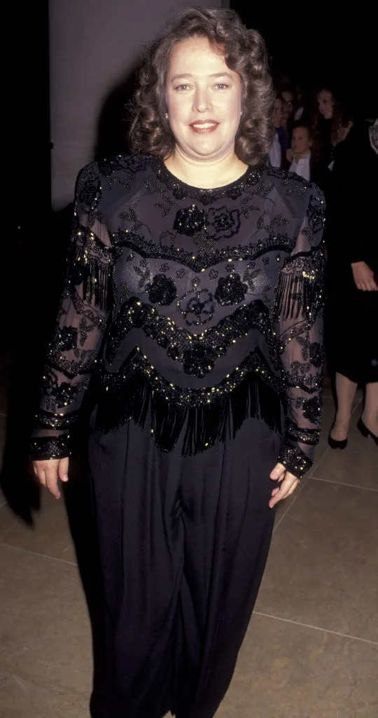 Person in an elegant black outfit with intricate beading and fringe detailing, attending an event