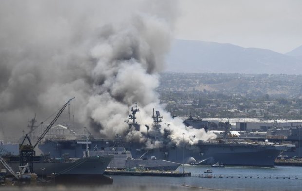 Smoke rises from the USS Bonhomme Richard at Naval Base San Diego Sunday, July 12, 2020, in San Diego after an explosion and fire Sunday on board the ship at Naval Base San Diego. (Photo by Denis Poroy, The Associated Press)