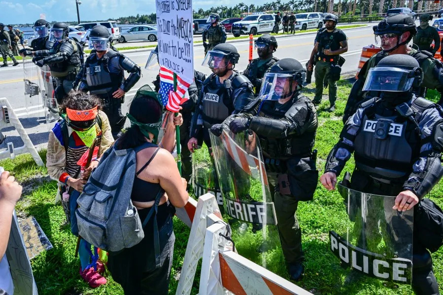 Demonstrators confront the police as they protest against the Trump administration during the “No Kings” rally near US President Donald Trump’s Mar-a-Lago home in West Palm Beach, Florida, on June 14, 2025. In response to the military parade celebrating the 250th anniversary of the US Army but also coinciding with Trump’s 79th birthday, a “No Kings” movement has sprung up promising to stage protests in more than 2,000 places across the country, including a large parade expected in Los Angeles which organizers say will feature a “20-foot-tall balloon of Trump wearing a diaper.” (Photo by Giorgio Viera / AFP) (Photo by GIORGIO VIERA/AFP via Getty Images)