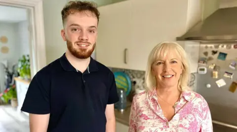 Martin Giles/BBC Joe and his mother Amanda Burgess in a kitchen