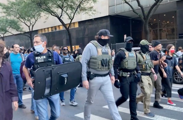Federal agents walk down Lafayette Street as demonstrators follow along after an immigration sweep on Canal Street through Chinatown, Tuesday, Oct. 21, 2025, in New York. (AP Photo/Jake Offenhartz)