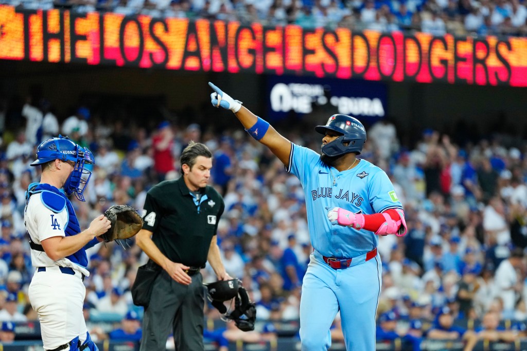 Toronto Blue Jays' Vladimir Guerrero Jr. (27) celebrates his two-run home run while crossing home plate as Los Angeles Dodgers catcher Will Smith (16) and umpire John Tumpane (74) look on during third inning Game 4 World Series playoff MLB baseball action in Los Angeles on Tuesday, Oct. 28, 2025.