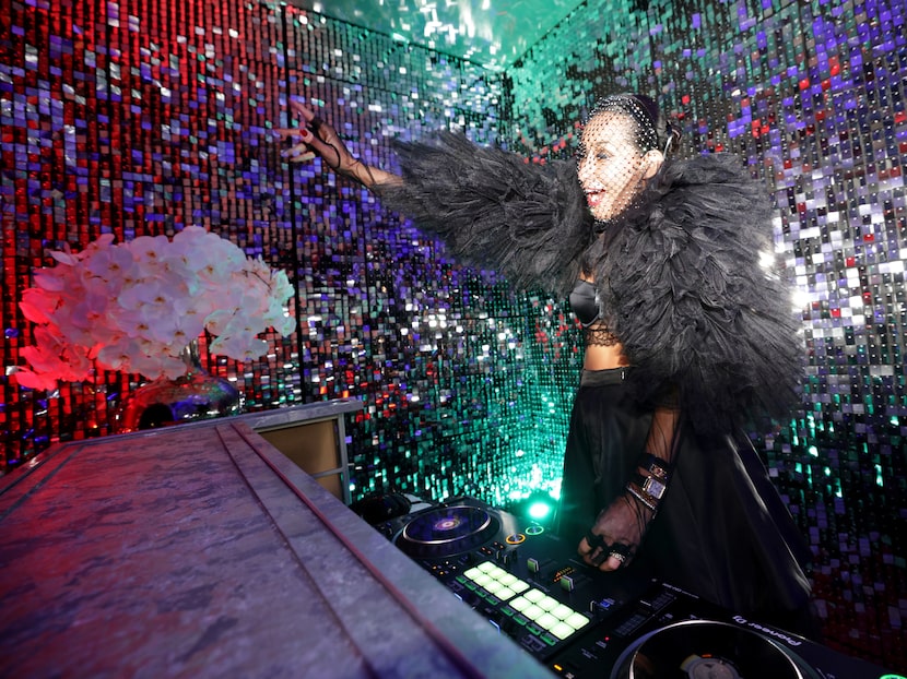 DJ RomiQ keeps the music going during cocktail hour at an amfAR event in Dallas, Texas, on...