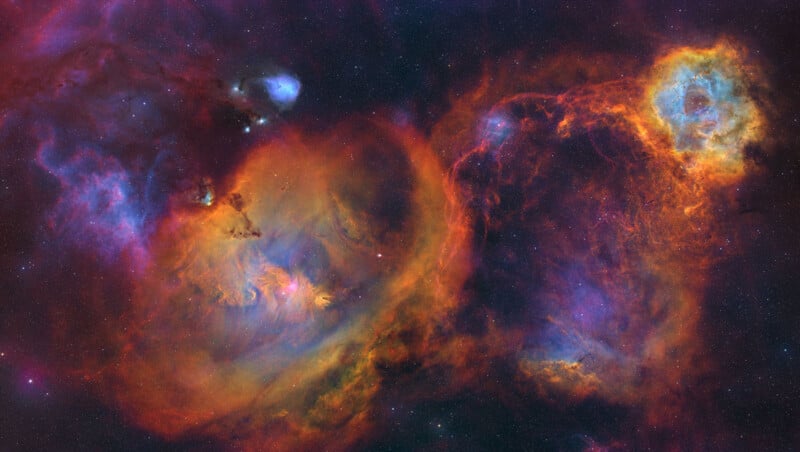 A vibrant, colorful image of outer space showing swirling clouds of orange, red, purple, and blue nebulae, with bright stars scattered throughout a dark background.